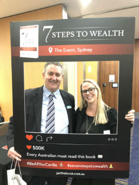 a happy couple is taking their photo when they attend 7 Steps to wealth event