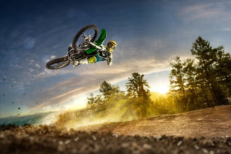 Dirt bike rider is flying high in evening